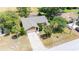 An elevated view of home with a screened-in lanai, tropical landscaping, and an extended brick-paved driveway at 5298 Florentine Ct, Spring Hill, FL 34608