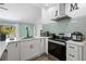 Modern kitchen features white cabinets, tile backsplash, stainless steel appliances, and updated lighting fixtures at 5298 Florentine Ct, Spring Hill, FL 34608