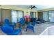 This covered patio has tile floors, blue lawn furniture, and dark sofa, great for outdoor entertaining at 5298 Florentine Ct, Spring Hill, FL 34608