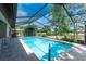 Relax in this sparkling private pool enclosed with screen, featuring lush landscaping at 5298 Florentine Ct, Spring Hill, FL 34608