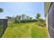Green backyard featuring an iron fence and landscaping running along the side of the house at 5548 Silver Sun Dr, Apollo Beach, FL 33572