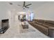 Spacious living room with modern tile floors, ceiling fan, and a comfortable brown sectional sofa at 5548 Silver Sun Dr, Apollo Beach, FL 33572