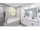 Tiled bathroom featuring a vanity with double sinks, a soaking tub, and a glass enclosed shower at 6302 Silver Oaks Dr, Zephyrhills, FL 33542