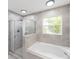 Modern bathroom showcasing a glass door shower, large soaking tub and tile accents at 6302 Silver Oaks Dr, Zephyrhills, FL 33542