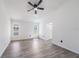 Bright bedroom featuring gray wood flooring, two windows, and a modern ceiling fan at 6302 Silver Oaks Dr, Zephyrhills, FL 33542