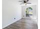 Bright bedroom with modern gray wood flooring, large arched window, and stylish ceiling fan at 6302 Silver Oaks Dr, Zephyrhills, FL 33542