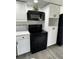 Well-equipped kitchen boasts white cabinets and black appliances for a stylish cooking space at 6302 Silver Oaks Dr, Zephyrhills, FL 33542