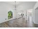 Bright, open-concept living area with modern flooring and large arched window at 6302 Silver Oaks Dr, Zephyrhills, FL 33542