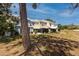 View of townhomes with backyards and a large tree in the foreground at 6600 121St Ave # 4, Largo, FL 33773