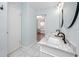 Light and airy bathroom featuring a dual vanity with black hardware and a door leading to another room at 6600 121St Ave # 4, Largo, FL 33773