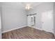 Empty bedroom with wood laminate flooring, ceiling fan, and ensuite bath behind sliding door at 6600 121St Ave # 4, Largo, FL 33773