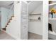 A bright hallway with wood-look tile, shelving, and under stair storage space provides charm and functionality at 6600 121St Ave # 4, Largo, FL 33773