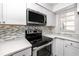 Modern kitchen features stainless steel appliances, white cabinets, and stylish backsplash at 6600 121St Ave # 4, Largo, FL 33773