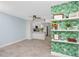 Open-concept living area with view to kitchen and shelving with green leaf wallpaper for visual interest at 6600 121St Ave # 4, Largo, FL 33773