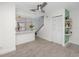 Bright living space with wood-look tile flooring, open to the kitchen and stairs, featuring stylish shelving at 6600 121St Ave # 4, Largo, FL 33773