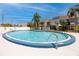 Community pool with clear blue water surrounded by a white fence and palm trees at 6600 121St Ave # 4, Largo, FL 33773
