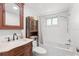 Well-lit bathroom with jacuzzi tub, vanity and decorative cabinet at 7025 Orkney N Ave, St Petersburg, FL 33709