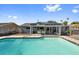 Inviting backyard oasis featuring a pristine pool, outdoor kitchen, and mature landscaping at 7025 Orkney N Ave, St Petersburg, FL 33709