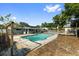 The backyard features a sparkling pool, covered patio with an outdoor kitchen, and a storage shed at 7025 Orkney N Ave, St Petersburg, FL 33709