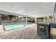Backyard oasis features a sparkling pool, covered patio, and outdoor kitchen with a sink and grill at 7025 Orkney N Ave, St Petersburg, FL 33709