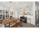 Open-concept dining area with sleek table, bench seating, and direct access to the modern kitchen at 8004 N Brooks St, Tampa, FL 33604