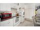 Compact kitchen featuring white appliances, functional layout, and easy access to the dining area at 8004 N Brooks St, Tampa, FL 33604