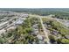 Aerial view showcasing the property's proximity to local roadways, industry, and lush green trees at 9236 Suncoast Terrace, Hudson, FL 34667