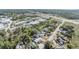 An aerial view of a property with a pool surrounded by an industrial complex and lush greenery at 9236 Suncoast Terrace, Hudson, FL 34667