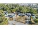 An aerial view of the property showcasing the home, additional buildings, and surrounding trees at 9236 Suncoast Terrace, Hudson, FL 34667