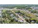 Aerial view showing the property with lush green trees, roadways, and nearby businesses at 9236 Suncoast Terrace, Hudson, FL 34667