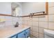 Bathroom featuring vintage tile walls, a blue vanity with sink, and tiled trim at 9236 Suncoast Terrace, Hudson, FL 34667