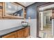 Modern bathroom featuring an elegant sink, wood accents, and a mirror with the doorway to the shower at 9236 Suncoast Terrace, Hudson, FL 34667