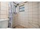 Tiled shower featuring updated shower head, window, and a built-in seat at 9236 Suncoast Terrace, Hudson, FL 34667