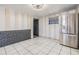 Breakfast nook with stainless steel fridge, striped walls, and tile flooring at 9236 Suncoast Terrace, Hudson, FL 34667