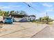 View of the home with a covered area and large driveway; a blue car is parked nearby at 9236 Suncoast Terrace, Hudson, FL 34667