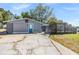 Single story home with gray exterior, brick accents, blue door, and an enclosed patio at 9236 Suncoast Terrace, Hudson, FL 34667