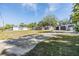 Sprawling front yard featuring a concrete drive, multiple buildings, and mature landscaping at 9236 Suncoast Terrace, Hudson, FL 34667