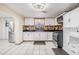 Open kitchen with white cabinets, stainless steel appliances, stone backsplash and tile flooring at 9236 Suncoast Terrace, Hudson, FL 34667