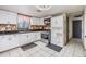 Well-lit kitchen featuring white cabinets, stainless steel appliances, and stone tile backsplash at 9236 Suncoast Terrace, Hudson, FL 34667