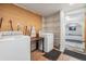 Functional laundry room with washer, dryer, wood accents, shelving, and entrance to another room at 9236 Suncoast Terrace, Hudson, FL 34667