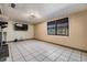 Cozy living area with tile floors, a mounted TV, and natural light from the large window at 9236 Suncoast Terrace, Hudson, FL 34667