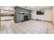 Open-concept living room showcasing tile floors, a brick fireplace, and seamless flow into the kitchen at 9236 Suncoast Terrace, Hudson, FL 34667