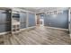 A room with neutral wood-look tile, a closet, blue walls, and a glimpse into a remodeled bathroom at 9236 Suncoast Terrace, Hudson, FL 34667