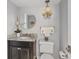 Elegant powder room with decorative lighting, a vanity with a marble countertop, and a round mirror at 10605 Carrollbrook Ln, Tampa, FL 33618