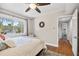 Relaxing bedroom featuring a large window view, ceiling fan, and hardwood floors at 10605 Carrollbrook Ln, Tampa, FL 33618