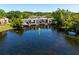 Waterfront townhomes with balconies overlook a tranquil lake, surrounded by mature trees and lush greenery at 10605 Carrollbrook Ln, Tampa, FL 33618