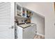 Bright laundry room equipped with a washer, dryer, and storage shelves, designed for convenience at 10605 Carrollbrook Ln, Tampa, FL 33618
