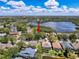 Aerial view of a tree-lined street and home location, near a lake at 1003 Teal Pointe, Tarpon Springs, FL 34689