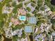Overhead view of the community featuring a pool, tennis courts, and nearby lake at 1003 Teal Pointe, Tarpon Springs, FL 34689