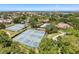 Aerial community view featuring tennis courts, swimming pool, and lush green surroundings at 1003 Teal Pointe, Tarpon Springs, FL 34689